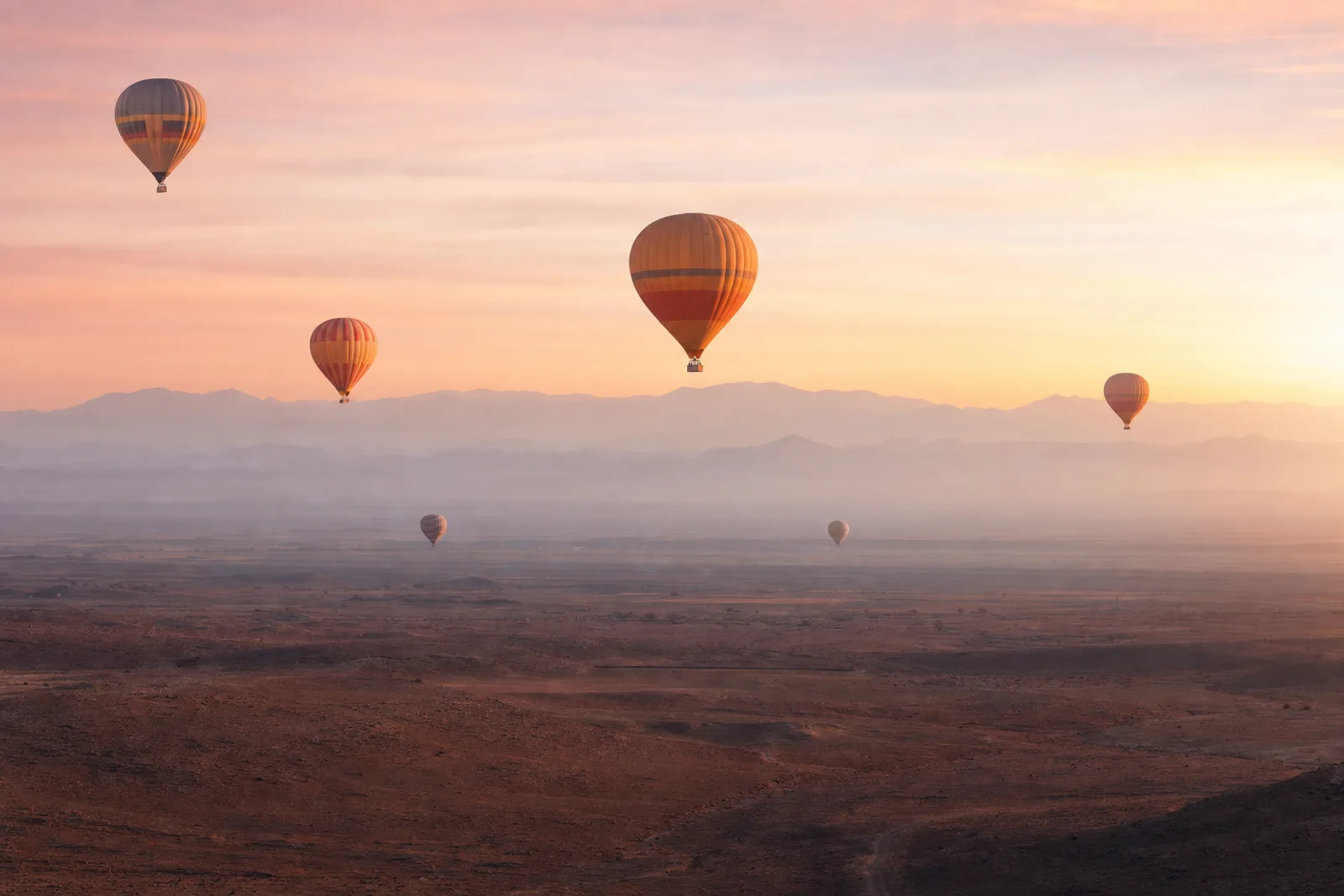Marrakech from above: sunrise hot air balloon flights - A pickup before dawn, a quiet climb over the plains outside the city, breakfast after landing. We pick and compare the balloon flights, paragliding tandems and combos actually worth booking — downsides included. Marrakech from above: sunrise hot air balloon flights